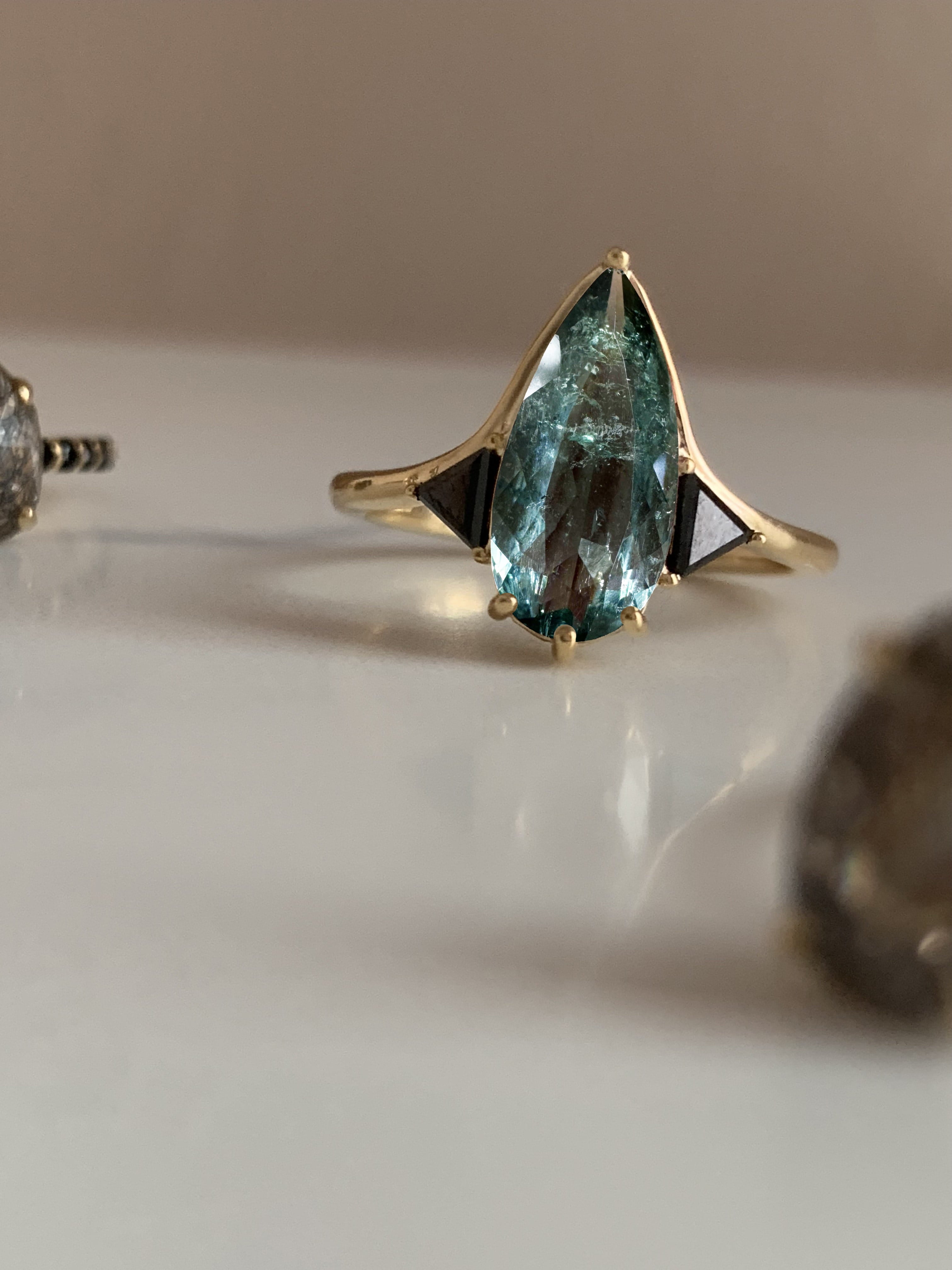 Blue Tourmaline Elongated Pear with Black Diamond Side Stones Engagement Ring